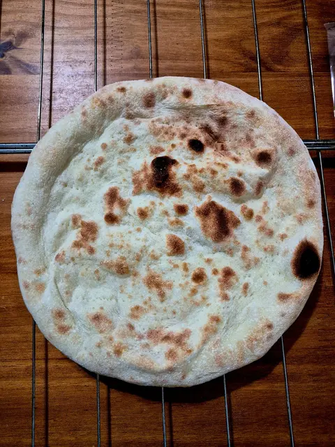 Disco de massa artesanal para pizza assado sobre uma grade